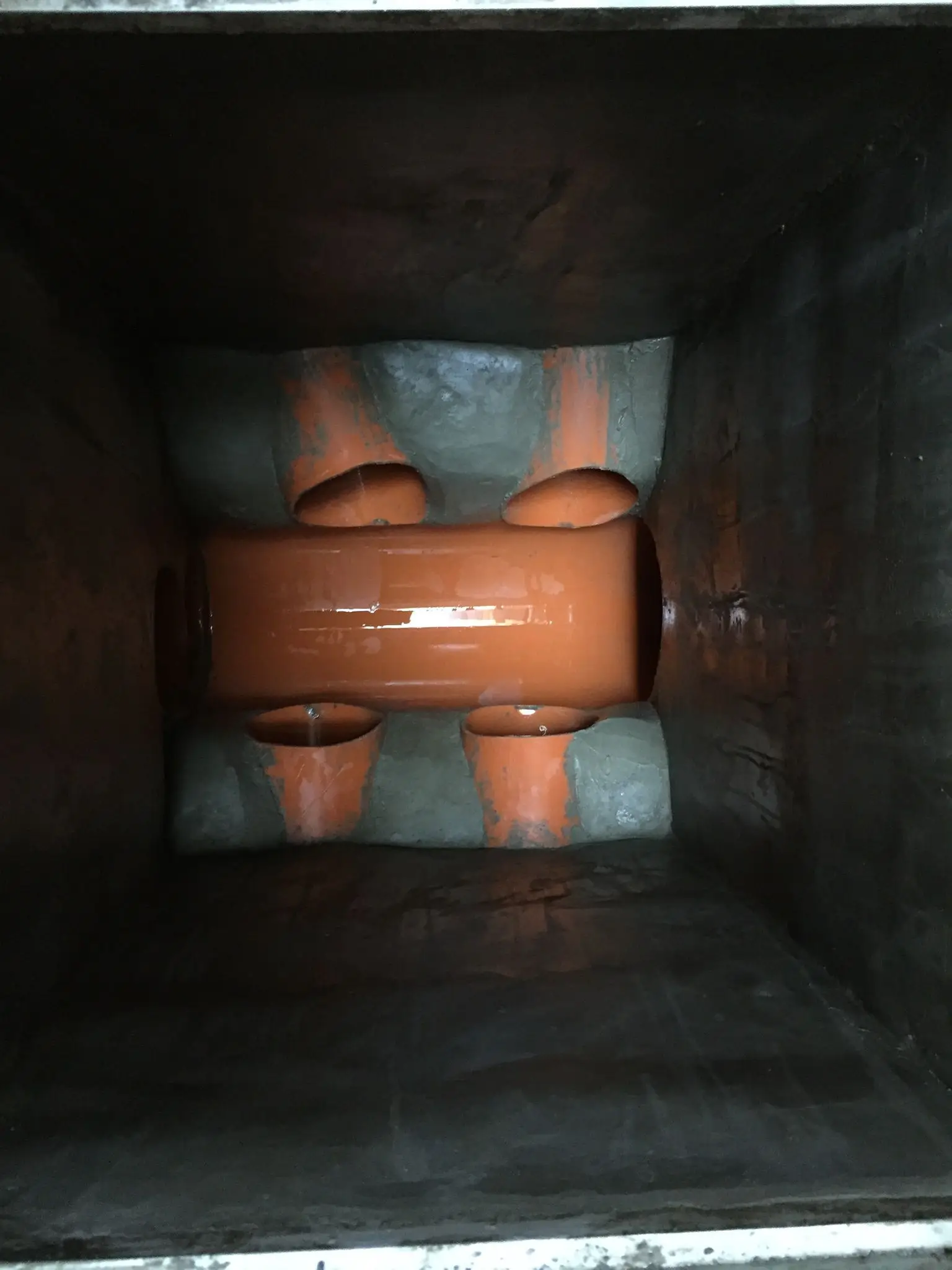 Trabajo de fontanería con arqueta de registro y conexiones de tuberías de PVC naranja en Madrid