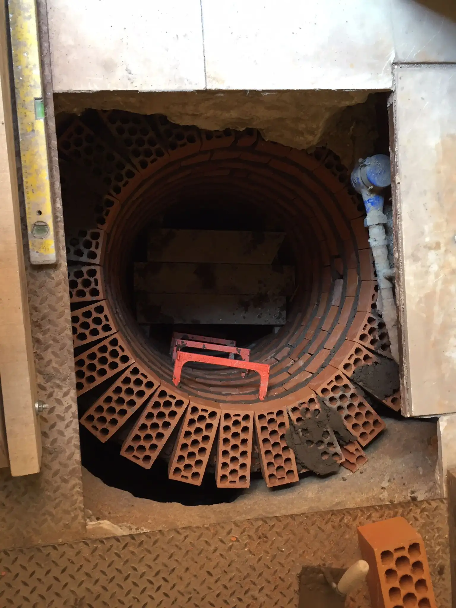 Trabajo de fontanería con pozo circular de ladrillo visto y tuberías de conexión en Madrid