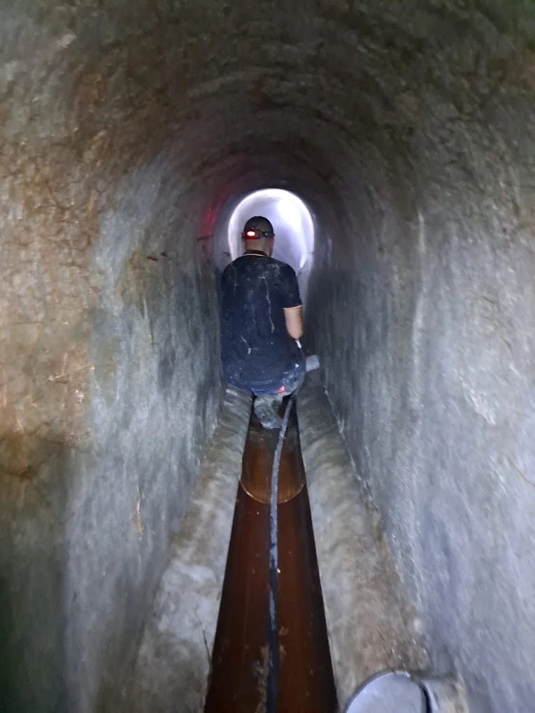 Operario de fontanería realizando la inspección de una tubería de saneamiento en un túnel en Madrid
